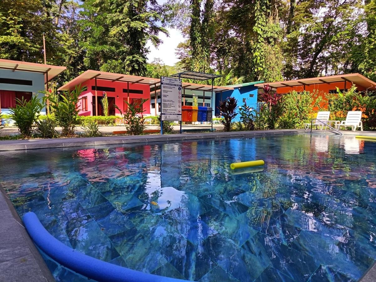The blue morpho mosaic set into the pool deck, with the coloured casitas beyond.